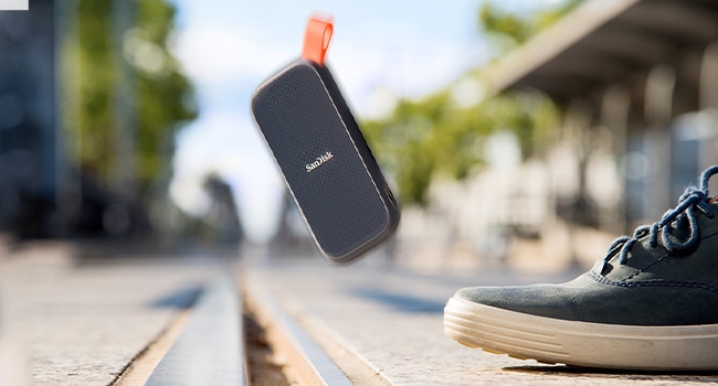 Portable SSD falling through the air next to a shoe