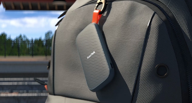Portable SSD hanging from a hook on a backpack
